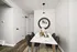 Chic dining nook with a marble table, elegant decor, and a stylish round mirror creating a modern and inviting ambiance.