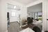 Elegant open-concept kitchen and living room with modern decor, wood flooring, and large windowed doors offering serene outdoor views.
