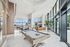 Luxurious apartment lounge with pool table, elegant seating, and floor-to-ceiling windows overlooking the cityscape.