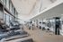 Luxurious gym with modern cardio machines, strength equipment, and expansive windows for natural light.