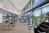 Modern apartment gym with large windows, sleek exercise equipment, and artistic wall design.