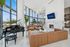 Luxurious living room with elegant leather sofas, grand piano, and panoramic city views through expansive floor-to-ceiling windows.