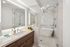 Luxurious modern bathroom with elegant glass shower, sleek vanity, and sophisticated neutral tones.