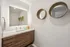 Modern bathroom with sleek wood cabinetry, elegant wall mirrors, and ambient lighting for a contemporary touch.