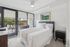 Chic bedroom with a comfortable bed, large window view, and outdoor balcony access.