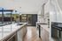 Modern kitchen with sleek appliances, quartz countertops, and large windows offering abundant natural light.
