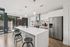 Modern kitchen with sleek cabinetry, stainless steel appliances, and a large island with stylish pendant lighting.