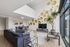 Modern living room with elegant decor, featuring stylish wall art, large black sofa, and expansive windows for natural light.