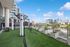 Luxurious rooftop fitness area overlooking city skyline, featuring modern exercise equipment and lush greenery for an invigorating workout experience.