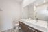 Elegant modern bathroom featuring double sinks, sleek fixtures, and a glass-enclosed shower.