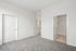 Bright, modern bedroom with plush carpeting and white doors, offering a cozy and inviting atmosphere.