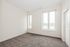 Bright and inviting empty room featuring large windows and plush carpeting, perfect for personalizing your space.