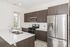 Modern kitchen with sleek stainless steel appliances, elegant dark wood cabinets, and a bright open design.