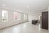 Bright and spacious modern apartment featuring an open floor plan with an elegant kitchen island, large windows, and sleek wood flooring.