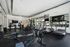 Modern fitness center featuring state-of-the-art equipment, including treadmills, rowing machines, and exercise bikes, set in a bright, spacious room with sleek mirrors and large windows.