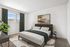 Bright and inviting bedroom featuring a modern double bed, abstract wall art, and lush greenery for a serene ambiance.