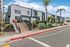Inviting leasing office of reNew apartments with modern architecture, surrounded by lush landscaping and vibrant balloons, showcasing a welcoming atmosphere.