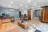 Elegant office space with stylish wooden furniture, a cozy leather couch, and modern decor featuring geometric wall art and sliding doors.