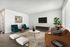 Chic living room with sleek modern furniture, plush seating, and a stylish coffee table, accented by a vibrant rug and abundant natural light.