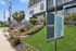 Inviting apartment complex with lush green landscaping, modern signage, and a welcoming leasing office at ReNew Serra Mesa.