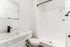 Modern bathroom featuring a sleek white sink, elegant vanity, and a spacious shower with a contemporary design.