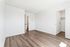 Bright bedroom with elegant wood flooring, walk-in closet, and fresh white walls, offering a canvas for personalized decor.
