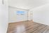 Bright and spacious apartment bedroom with large window, elegant wood flooring, and a convenient walk-in closet.