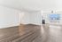 Bright modern apartment with open living space, sleek hardwood floors, and abundant natural light through large windows.