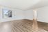Bright and airy apartment interior featuring elegant wood flooring, large window with a view, and crisp white walls for a modern look.