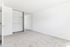 Bright and spacious empty room with plush carpet and large mirrored closet doors, ideal for customization.