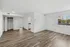 Bright and airy living space with sleek hardwood floors, large window for natural light, and modern open layout.