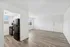 Bright and modern open-plan living space featuring a stylish kitchen with sleek appliances and elegant wood flooring.