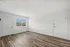 Bright and airy living space with elegant wood flooring and large window offering scenic views.