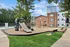 Inviting residential playground with modern slide, surrounded by lush greenery and contemporary apartment buildings, perfect for family living.