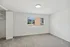 Bright and spacious bedroom with a large window offering a charming suburban view, featuring plush carpet and ample closet space.