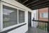 Charming apartment entry with modern white brick exterior and large window bringing in natural light.