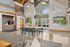 Chic and modern communal area with high ceilings, large windows, and wooden beams, featuring a spacious table perfect for gatherings, set in a bright and inviting environment.