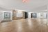Modern apartment hallway with stylish wooden flooring, vibrant mailbox area, and bright lighting, exuding contemporary elegance and inviting warmth.