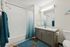 Modern bathroom with elegant cabinetry, sleek fixtures, and soothing teal accents creating a serene atmosphere.