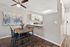 Contemporary dining area with stylish wooden table, cozy padded chairs, and artistic wall decor, adjacent to a modern kitchen with sleek cabinets and stainless steel appliances.