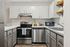 Chic modern kitchen with stainless steel appliances, sleek white cabinetry, and subway tile backsplash.