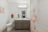 Elegant bathroom featuring a modern vanity with ample storage, sleek fixtures, and a vibrant floral shower curtain creating a fresh, inviting atmosphere.