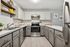 Modern kitchen with sleek gray cabinets, stainless steel appliances, and elegant white subway tile backsplash.
