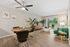 Chic open-plan living and dining area with stylish decor, lush greenery, and large windows overlooking a scenic garden.