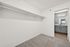 Spacious walk-in closet with plush carpeting and a stylish bathroom view, offering modern living with ample storage.