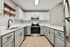 Elegant modern kitchen featuring sleek white cabinets, stainless steel appliances, and chic black fixtures, showcasing a bright and spacious culinary space.
