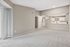 Bright and spacious open-concept apartment with plush carpet, modern kitchen, and ample natural light.