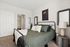 Cozy bedroom with modern decor, featuring a plush bed, stylish bedside table, and inviting bathroom access, perfect for comfort and convenience.