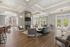 Luxurious and modern apartment lounge with sleek furniture, elegant fireplace, and abundant natural light through large windows.