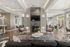 Luxurious living room with modern decor, featuring a stylish fireplace, elegant seating, and abundant natural light from large windows.